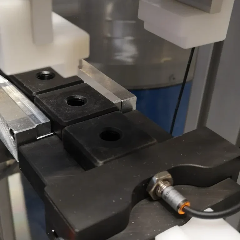 Nahaufnahme eines Sensors auf einem Linearförderer als Bestandteil der Zuführtechnik